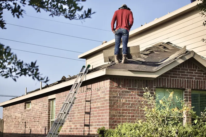 Professional roofer working on a residential roof in Tiverton